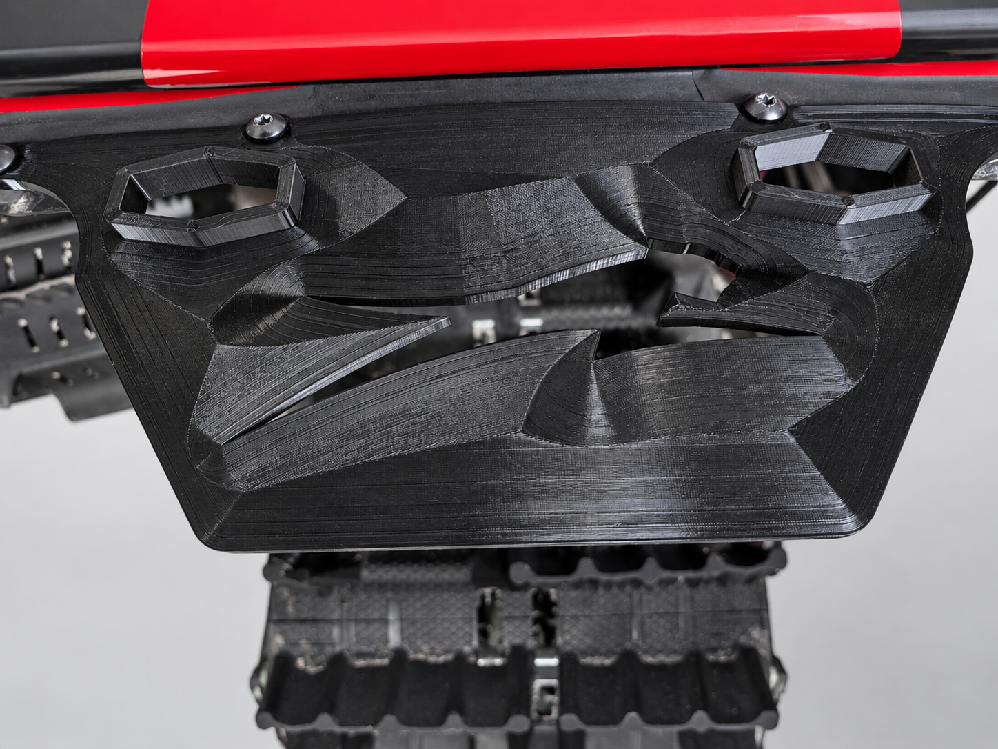 Black printed snowflap adapter mounted below the rear reflector, showing two attachment openings