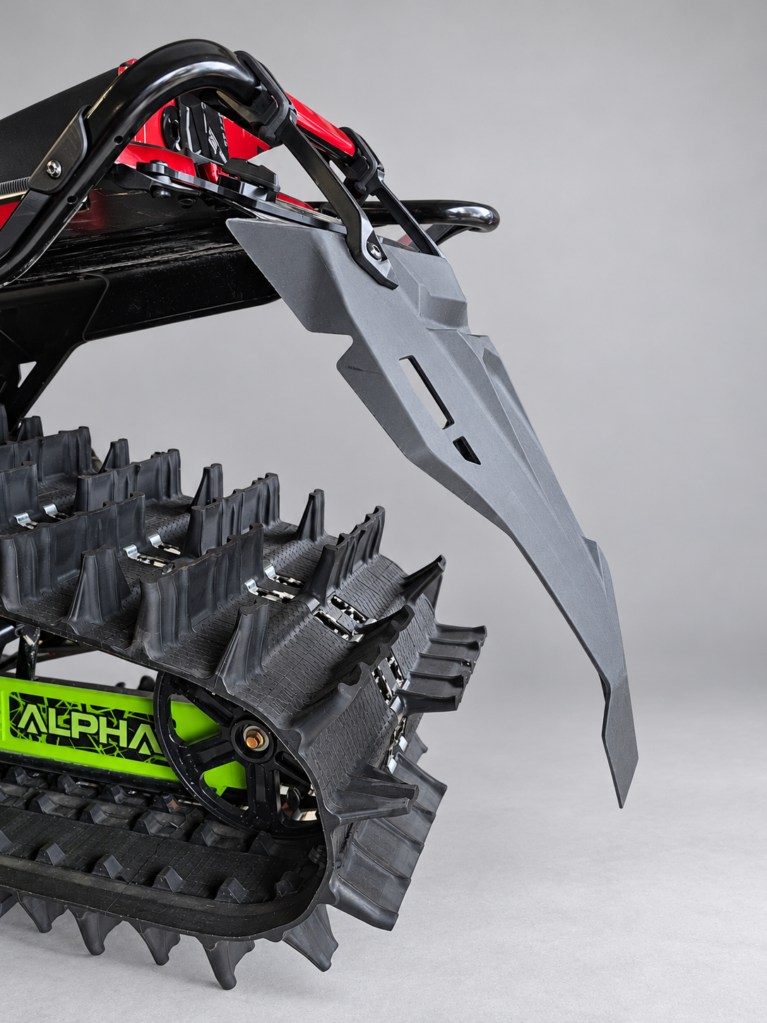 Side view of the detachable snowflap hanging behind the snowmobile track