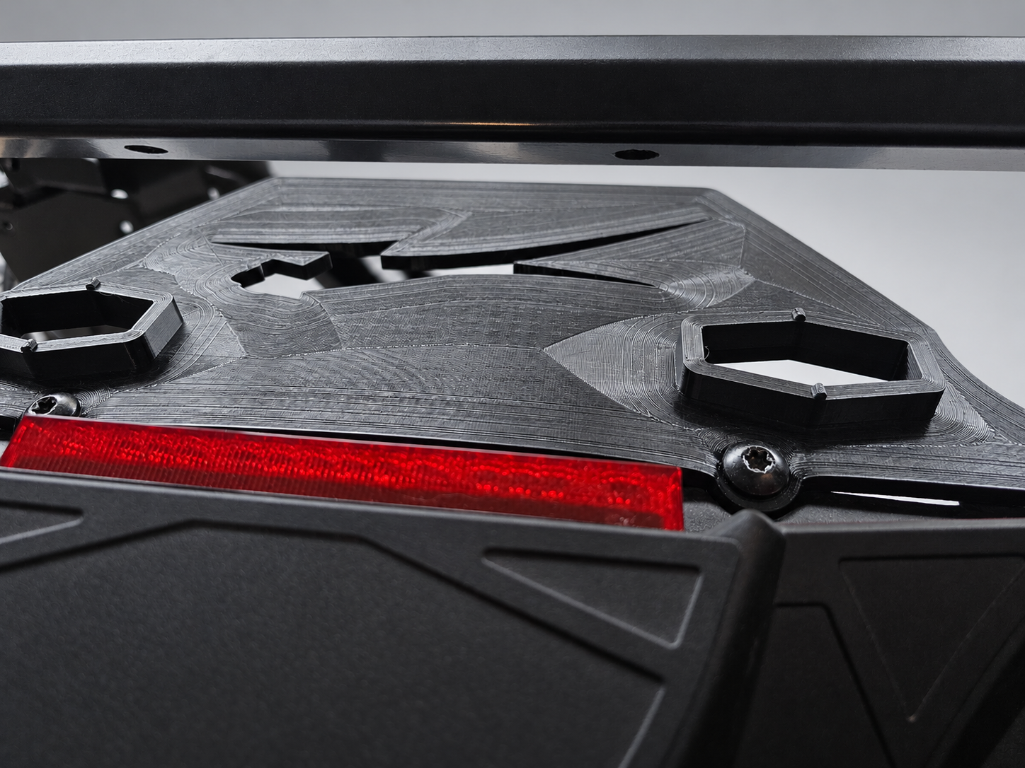 Low-angle detail showing the printed adapter, attachment sockets and mounting screws