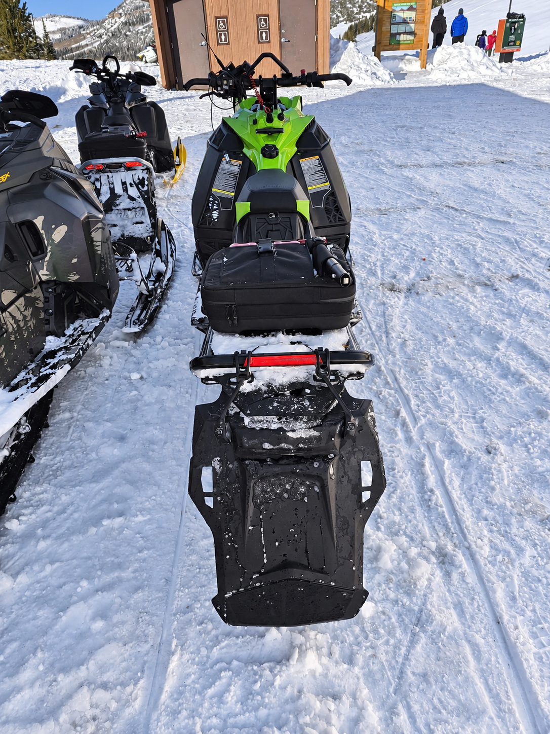 Rear view of a green Catalyst with the development snowflap fitted in packed snow